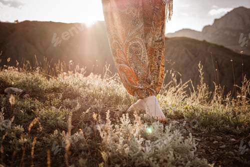 Preview: Red-haired cute woman resting in sunset mountains