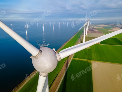 Preview: Windmill turbines at sea seen from a drone aerial view from above at a huge winmill park