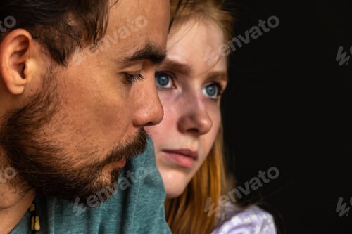 Preview: Pensive young couple hugging and looking to distance