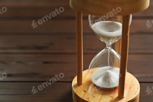 Preview: Hourglass with flowing sand on table. Time management