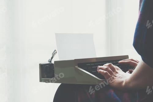 Preview: Girls hands typing in vintage typewriter