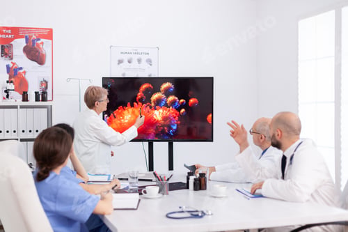 Preview: Virolog senior woman discussing about coronavirus symptoms during meeting in conference room