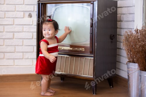 Preview: Full Length Of Cute Baby Girl Wearing Santa Costume While Sitting With Christmas Decorations