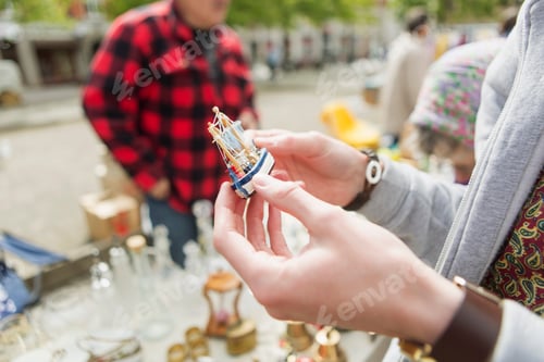 Preview: Cropped image of man holding antique ship toy at flea market
