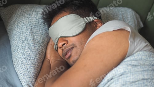 Preview: Man sleeping with eye mask in bed during the night