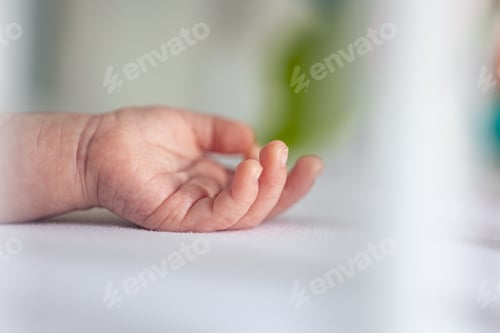 Preview: Close-up, the hand of a newborn baby on a blurred background.