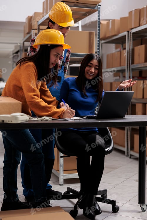 Preview: Warehouse workers checking order pick ticket on laptop