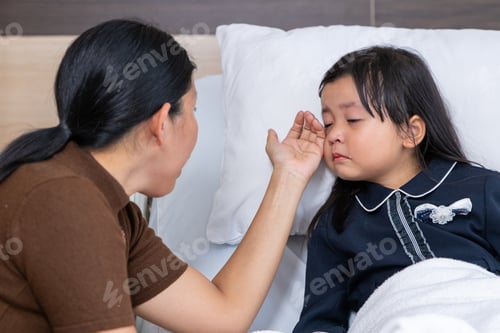 Preview: Mother comforting sick child in hospital bed