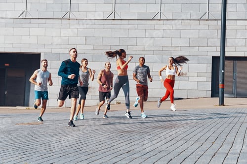 Preview: Full length of young people in sports clothing jogging while exercising outdoors