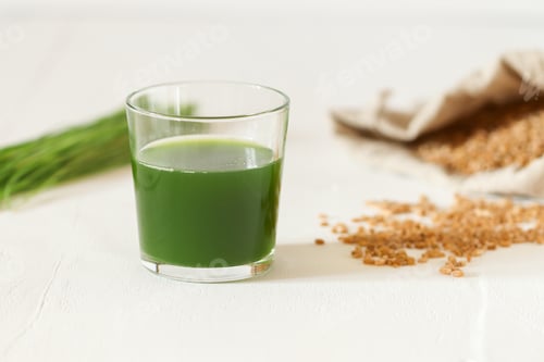 Preview: On a light background there is a glass with stained glass, wheatgrass juice.