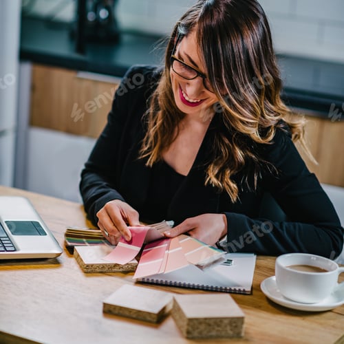 Smiling Woman Chooses Colors at a Work Table