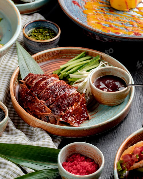Preview: side view of traditional asian food peking duck with cucumbers and sauce on a plate