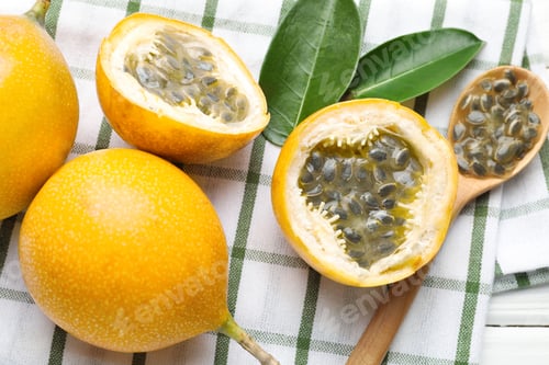 Preview: Ripe passion fruits, green leaves and seeds on table, flat lay