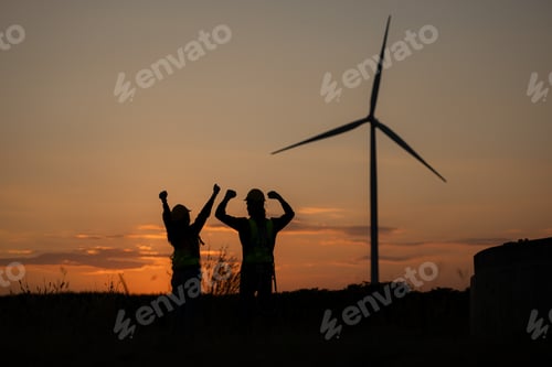 Preview: Silhouette of Engineer in charge of wind energy against a background of wind turbines.