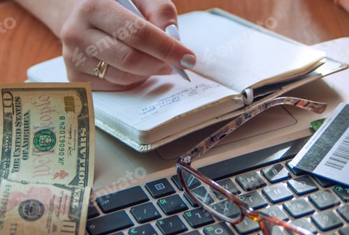 Preview: the girl counts the money and makes notes in the notebook,