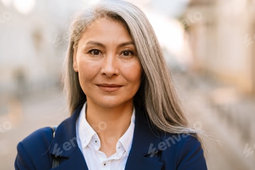 Preview: Mature asian woman with grey hair posing and looking at camera