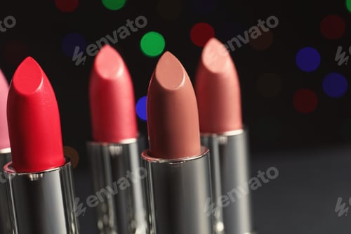 Preview: Different lipsticks against blurred lights. Cosmetic product