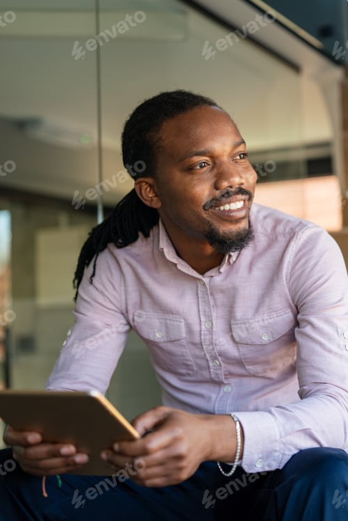 Preview: Smiling Man Holding Tablet Inside an Office Space