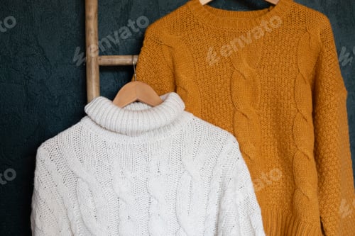 Preview: Warm autumn sweaters on hangers. Comfort knitwear for cold days