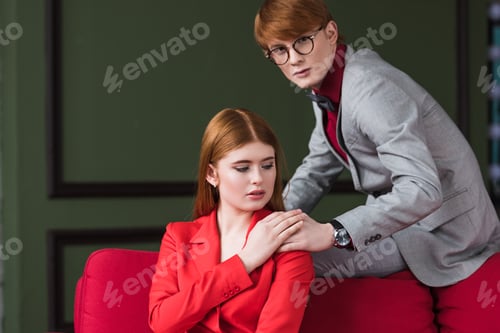 Preview: Young male with wristwatch and eyeglasses holding hand on female shoulder