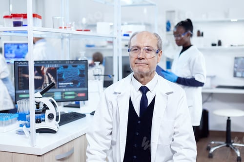 Preview: Senior male chemist looking at camera