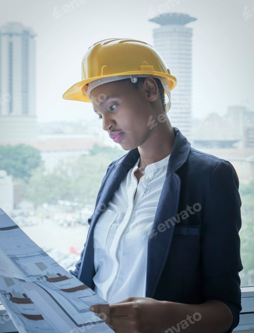Preview: Woman in hard hat looking at building plans