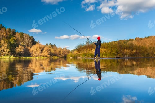 Preview: Fisherman boy on panoramic landscape with wide broad river in autumn forest