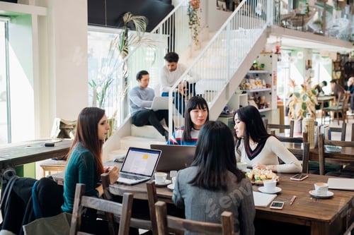 Preview: Young businesswomen remote working having meeting at cafe table