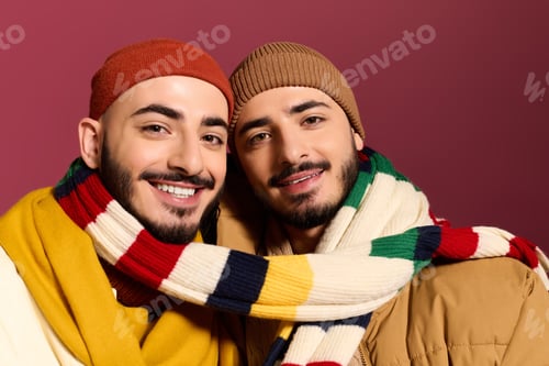 Preview: Stylish twins share a warm embrace in colorful scarves against a vibrant background