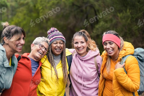 Preview: Happy multiracial women having fun during trekking day into the woods