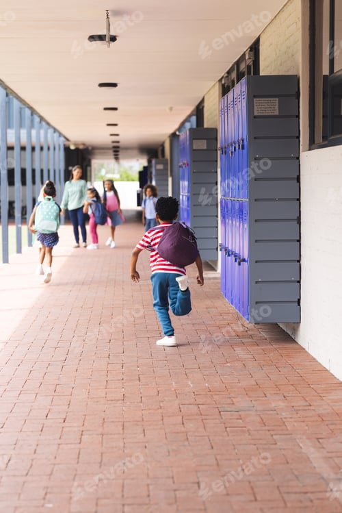 Preview: In school, diverse children are walking down hallway with lockers with copy space outdoors