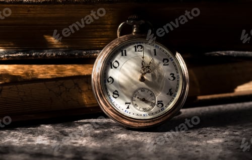 Preview: Vintage pocket watch, old books in the background.