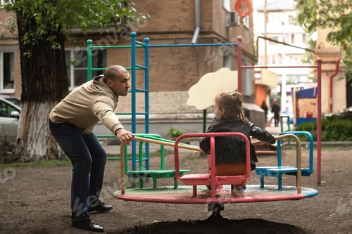Preview: family having fun on the playground on a swing