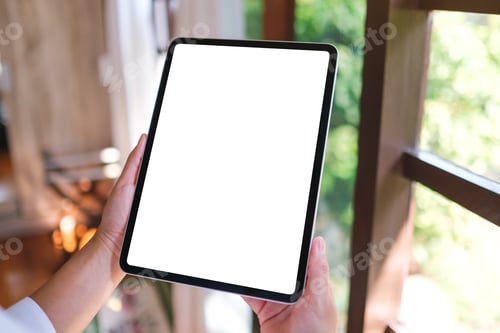 Preview: Mockup image of a woman holding tablet with blank desktop white screen at home