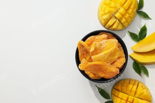Preview: A bowl of dried mango chips with fresh sliced mango