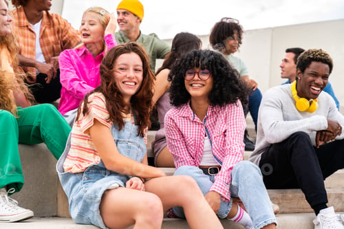 Preview: Happy playful multiethnic group of young friends bonding outdoors