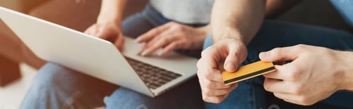 Preview: panoramic shot of woman using laptop near man with credit card