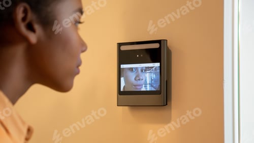 Preview: A face scanner being used by a woman to open a door at an office building.
