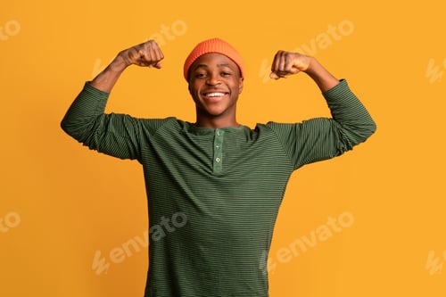 Preview: Strong Black Hipster Guy In Orange Hat Showing Biceps Muscles At Camera