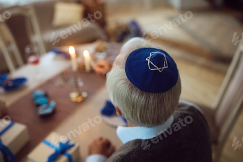 Preview: Close up of senior Jew lighting the menorah on Hanukkah.