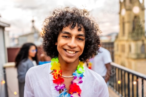 Preview: Man in Hawaiian necklace smiling during partying on rooftop