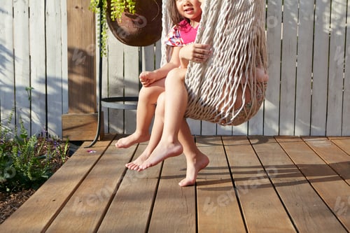 Preview: Girls sitting in hammock on porch