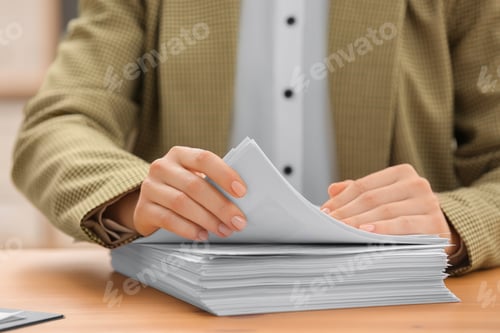 Preview: Woman working with documents at table in office, closeup