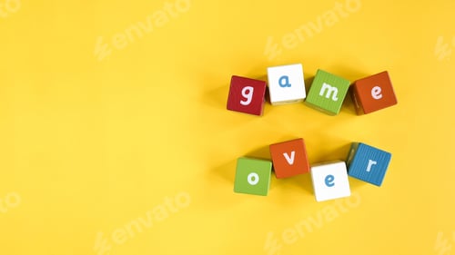 Preview: Words Game Over made from colored wooden blocks. Painted cubes with letters on yellow background.