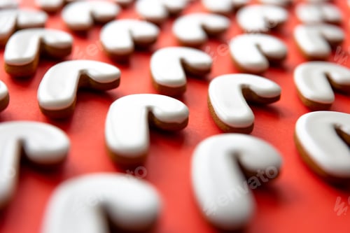 Preview: A lot of gingerbread candy cane shaped cookies on a red background.