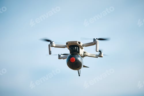 Preview: consumer civilian drone with a big bomb on board flies in the blue sky