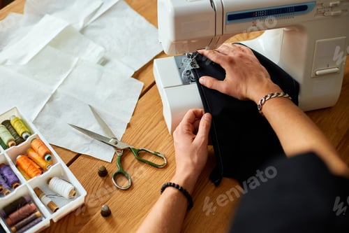 Preview: Man sews clothes on sewing machine, male tailor working with sewing in atelier