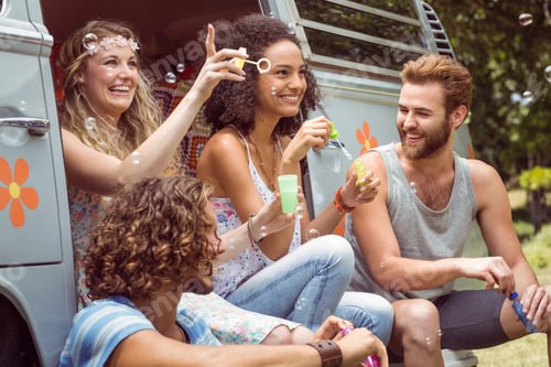Preview: Hipsters blowing bubbles in camper van on a summers day