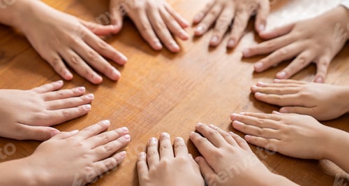 Preview: Multicultural hands man woman children in circle on brown wooden background