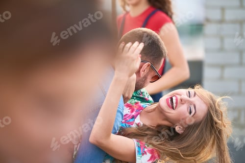 Preview: Young Caucasian Man Hugging Woman Laughing Outdoors